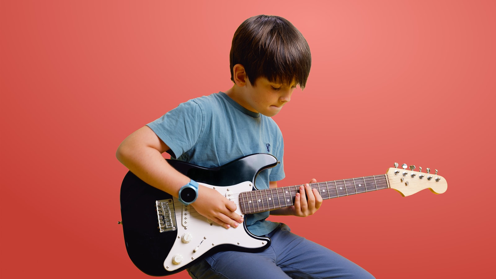 Boy playing guitar with Soundbrenner Spark