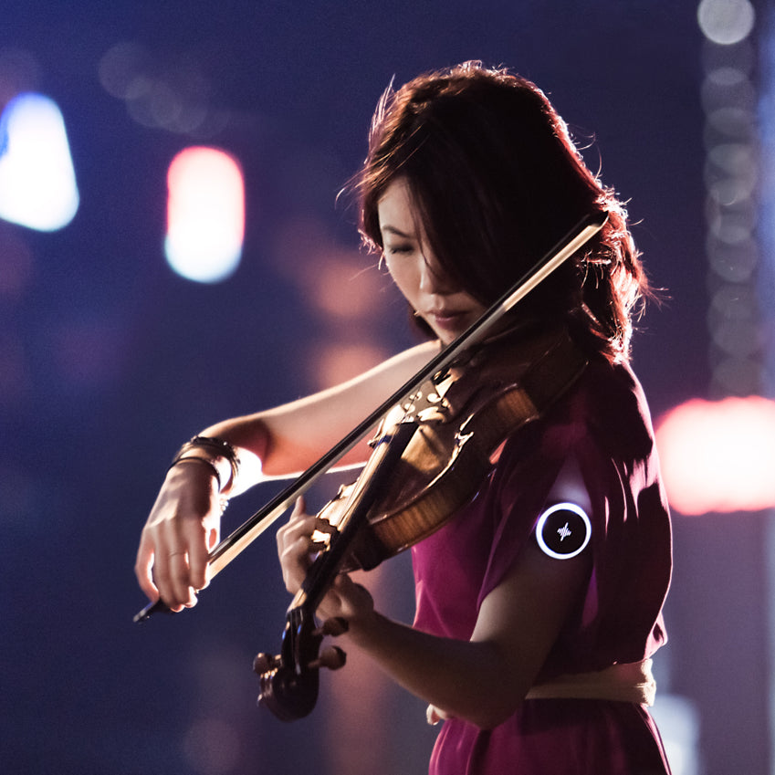 Violinista che si esibisce sul palco sotto luci colorate