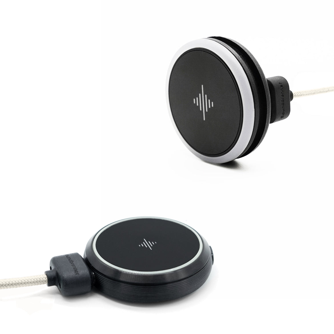 Two black round wearable devices with white charging cable connectors