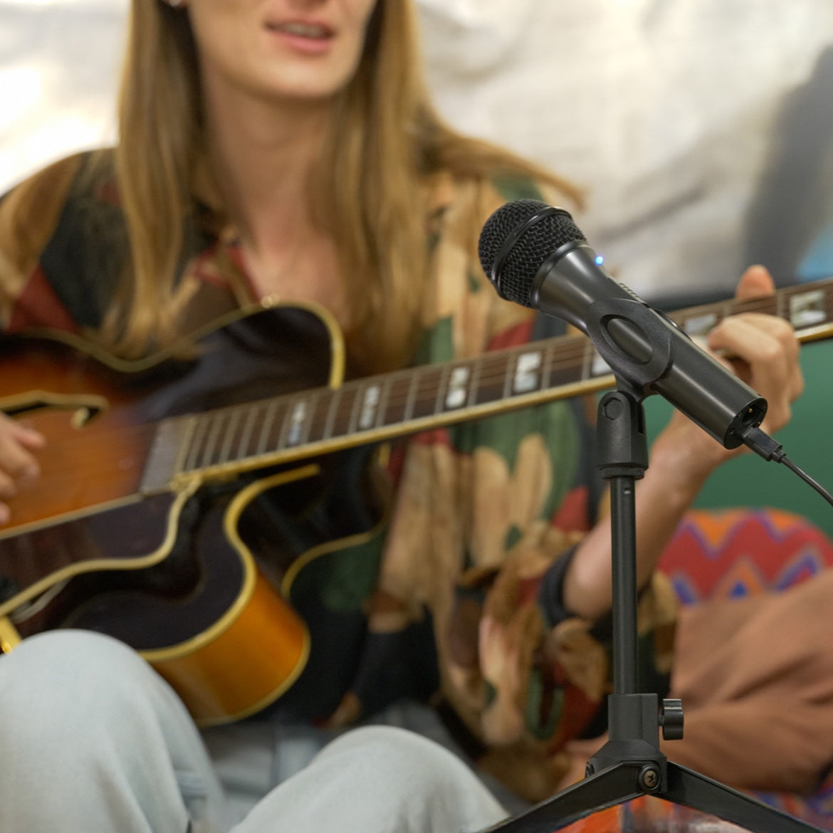 Flow microphone in front of a woman playing an acoustic guitar