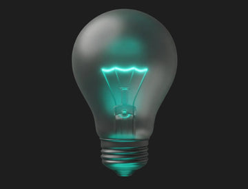 Glowing teal light bulb on a dark background