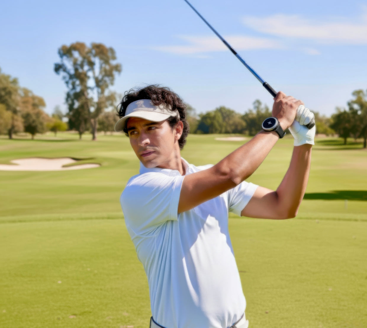 Golfer swinging a club on a course while wearing a round wrist device