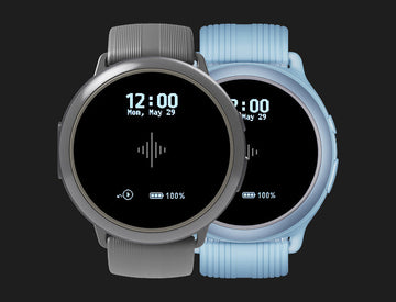 Two round wearable metronomes with gray and light blue bands displaying the time
