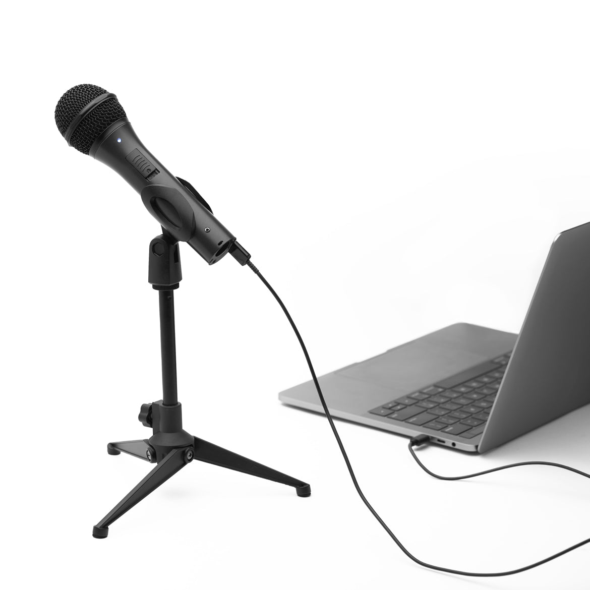 Black microphone on a desktop stand connected by cable to a laptop
