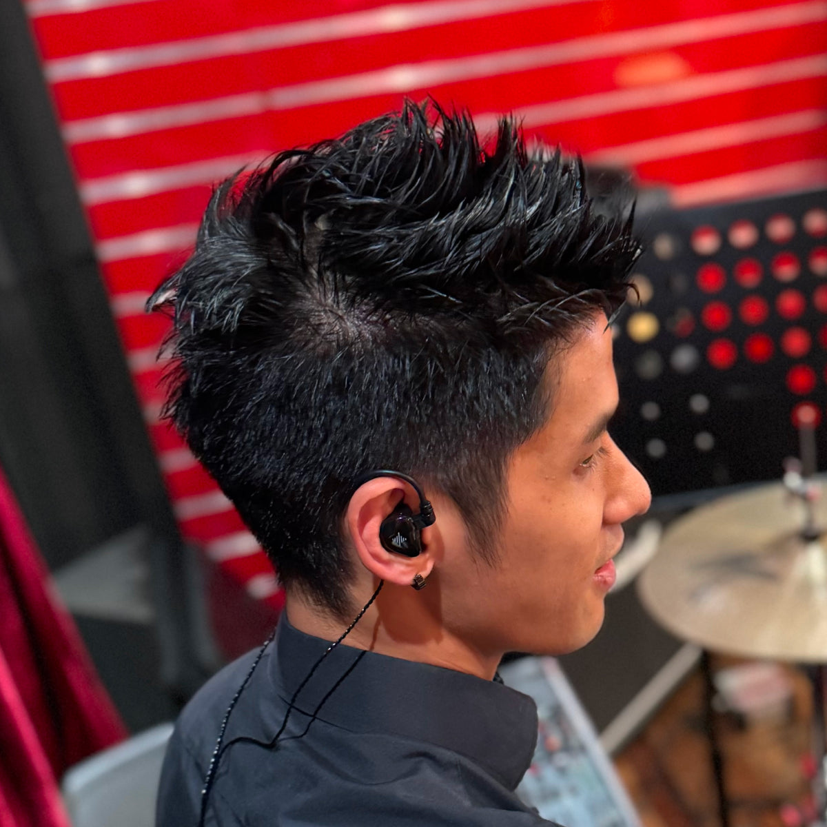 Person wearing a black earbud with a blurred background