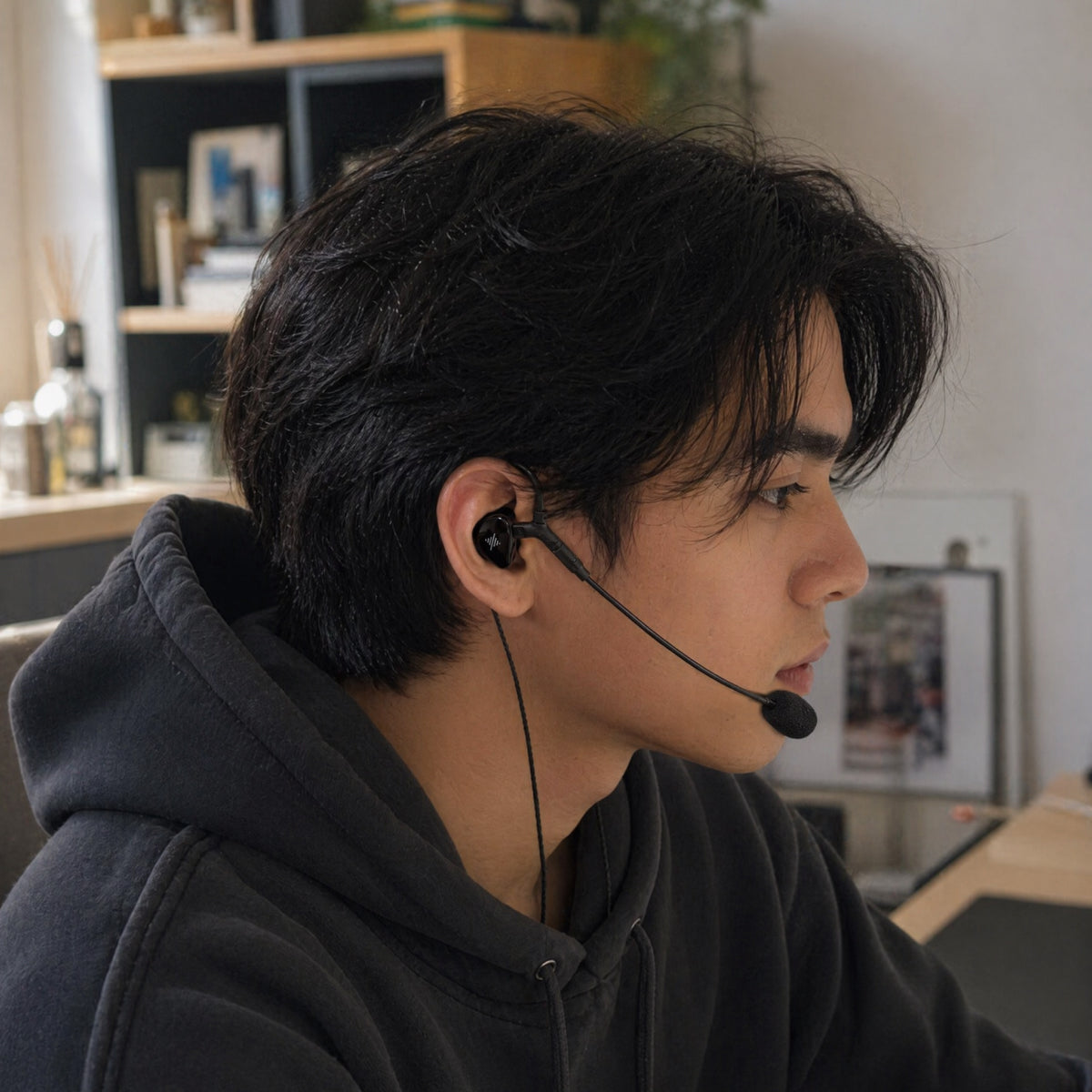 Person wearing black wired earphones with a boom microphone