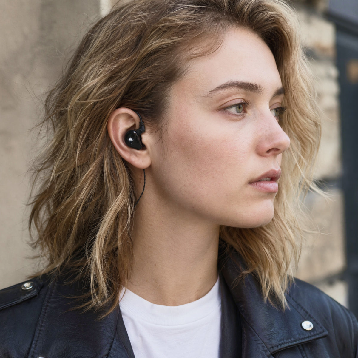 Person wearing a black Wave in-ear monitor