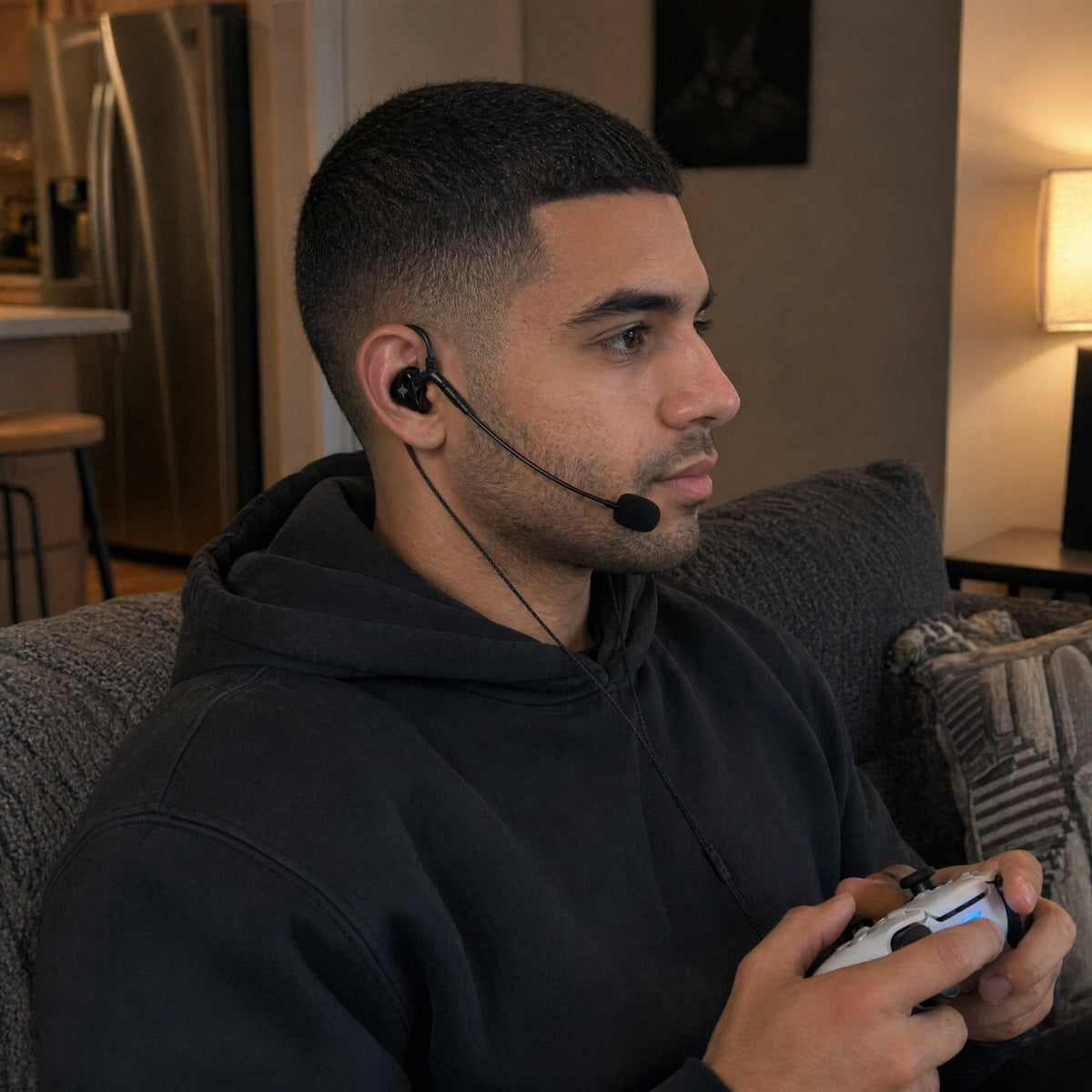 Person wearing wired earphones with a boom microphone while holding a game controller