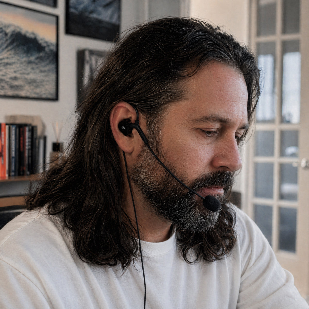 Person wearing wired earphones with a boom microphone