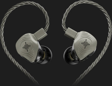 Pair of silver in-ear monitors with braided cables on a dark background