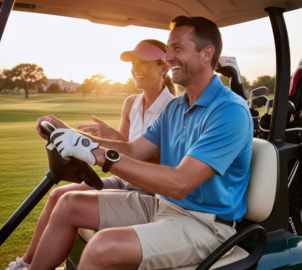 Smiling couple riding in a golf cart at sunset