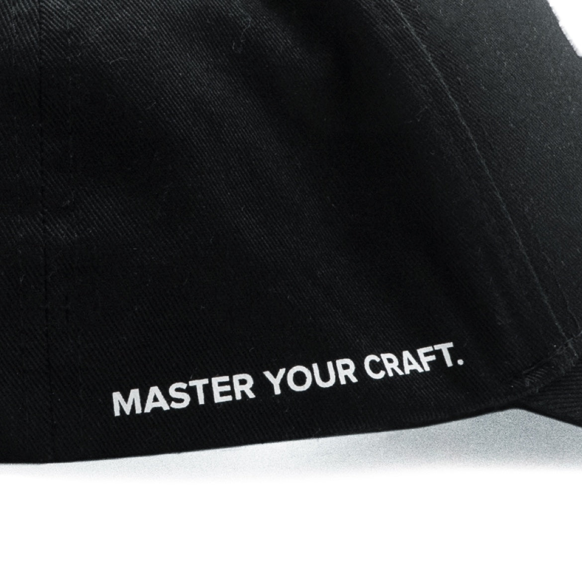 “MASTER YOUR CRAFT” शब्दों वाली काली बेसबॉल कैप का क्लोज़-अप