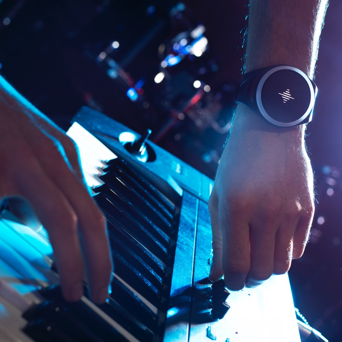 Músico tocando el piano con un metrónomo circular en la muñeca