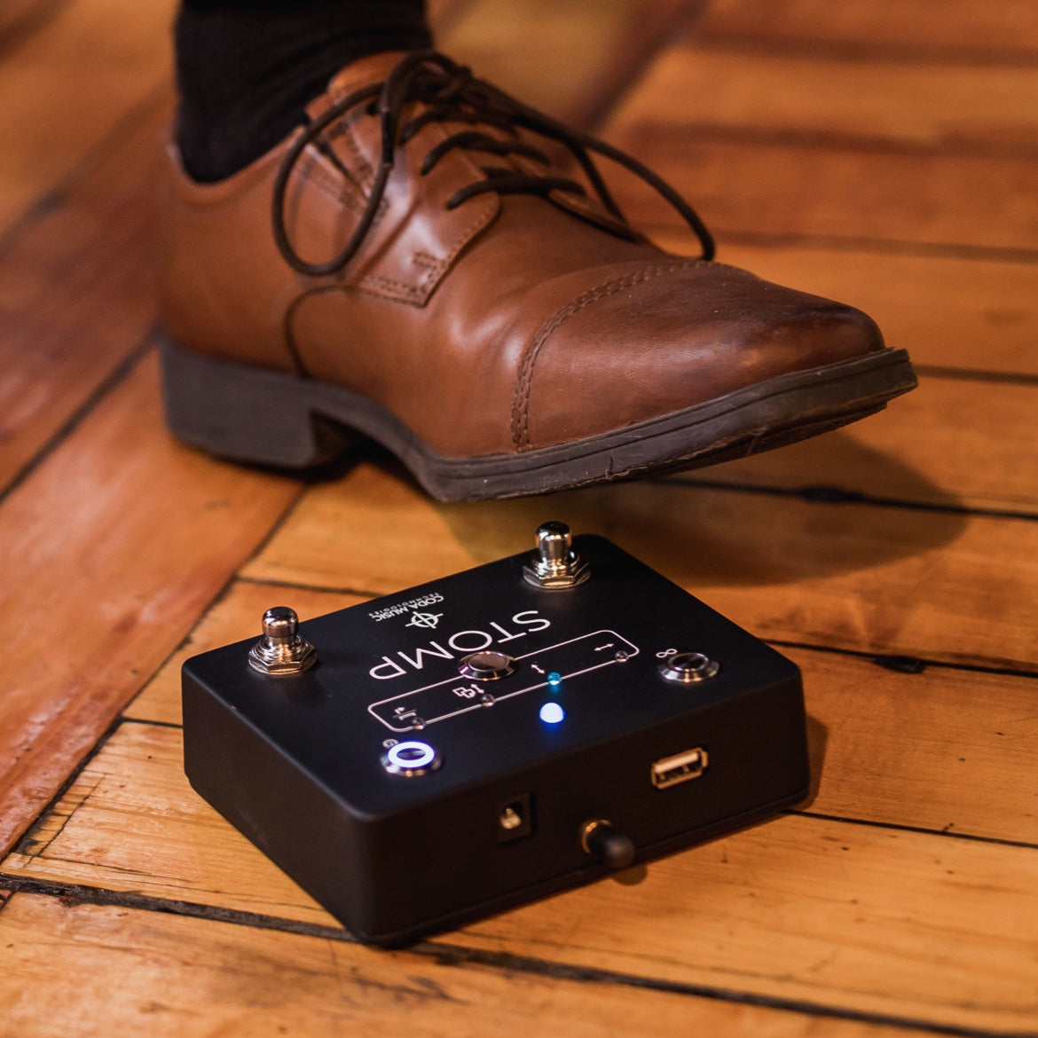 Brown shoe positioned above a black Soundbrenner Stomp pedal