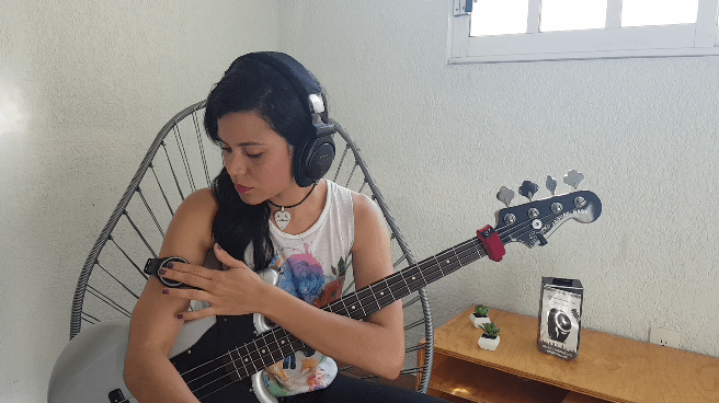 Lady focuses on rhythm on the bass guitar while using the soundbrenner pulse